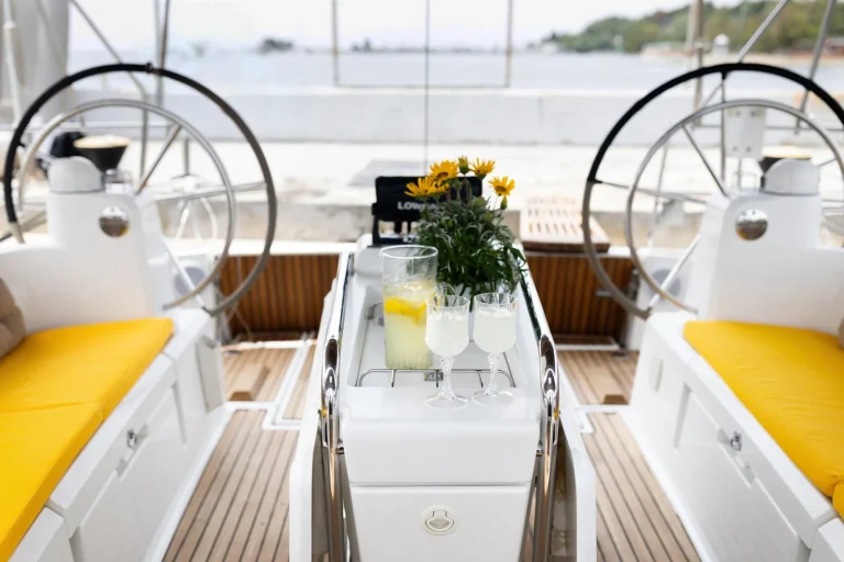 Lemon’s cockpit table with drinks between yellow-cushioned seats and two helm wheels
