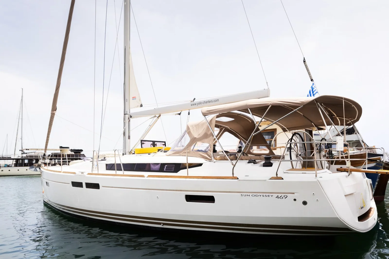 YOLO's Lemon sailing yacht moored alongside, showing its cockpit and bimini