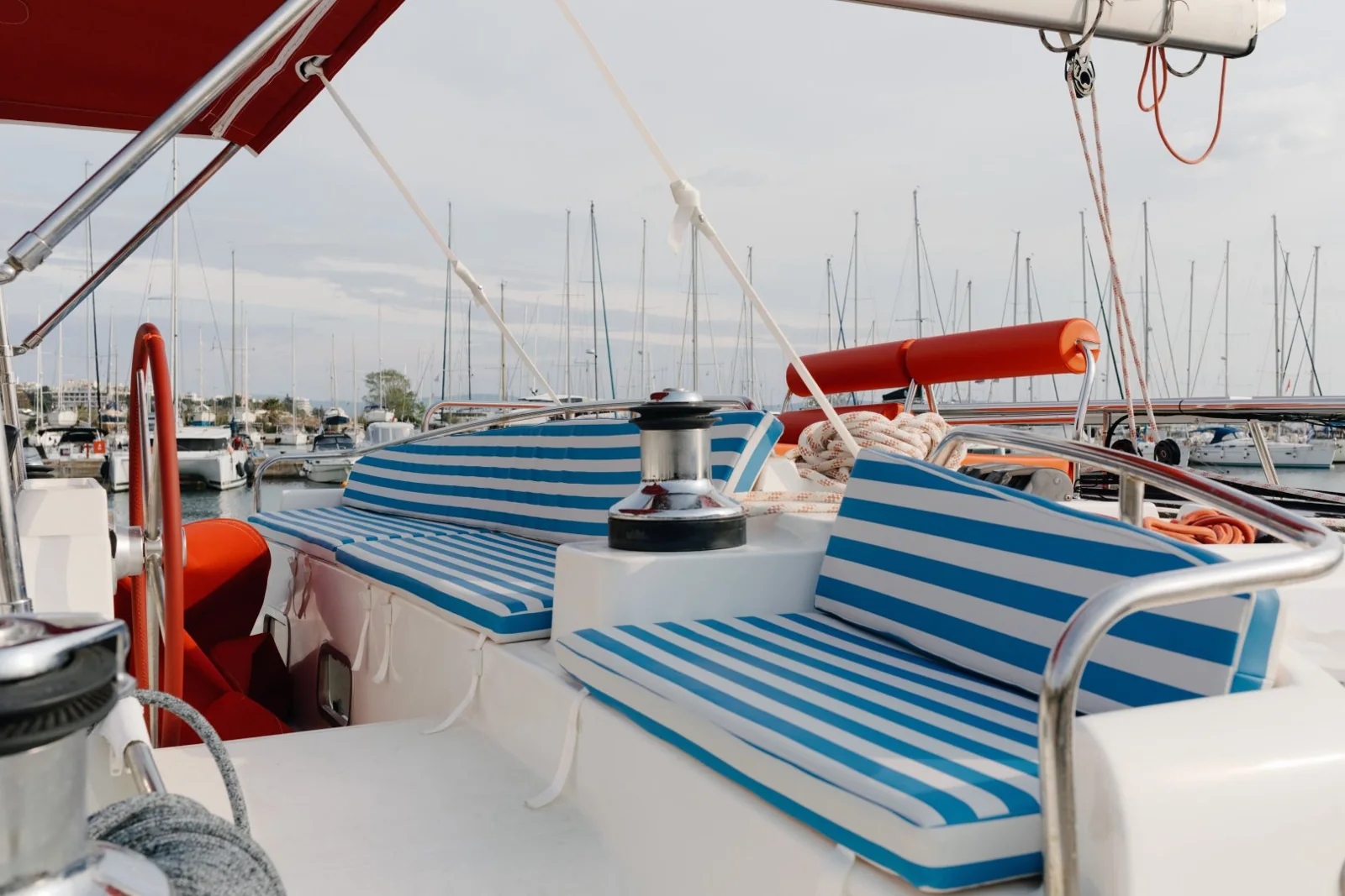 Striped cushions and deck seating beside rigging aboard Strawberry in a marina