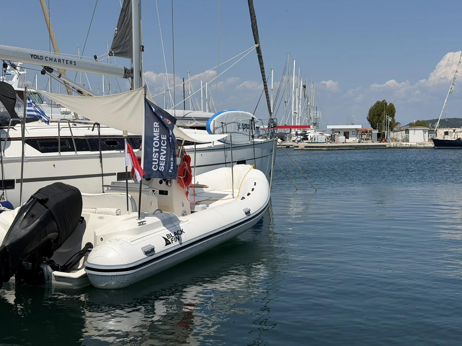 Λευκό φουσκωτό υποστήριξης της YOLO με σημαία εξυπηρέτησης πελατών και καλυμμένη εξωλέμβια μηχανή