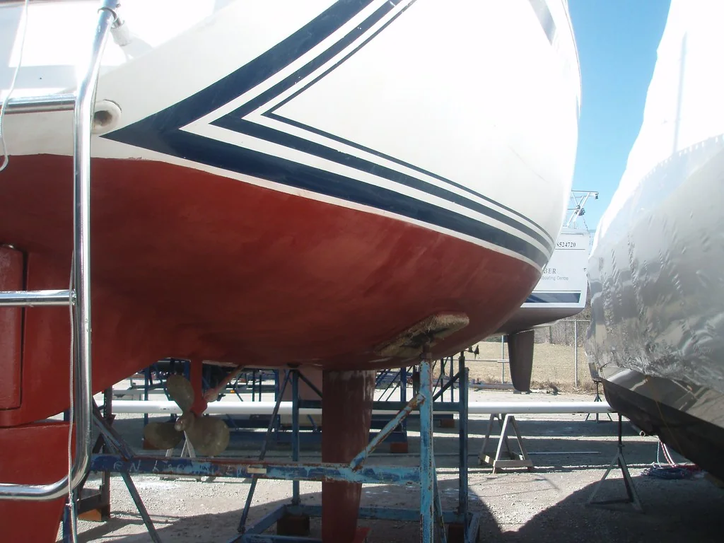 Sailing-yacht stern ashore showing the underwater coating, rudder and propeller.
